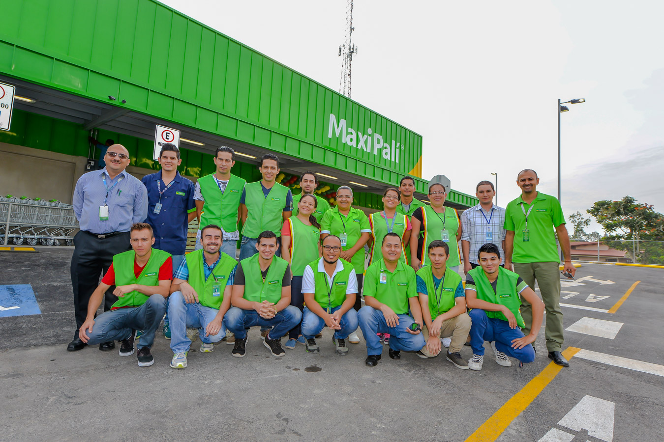 Associates in green shirts in front of green storefront 